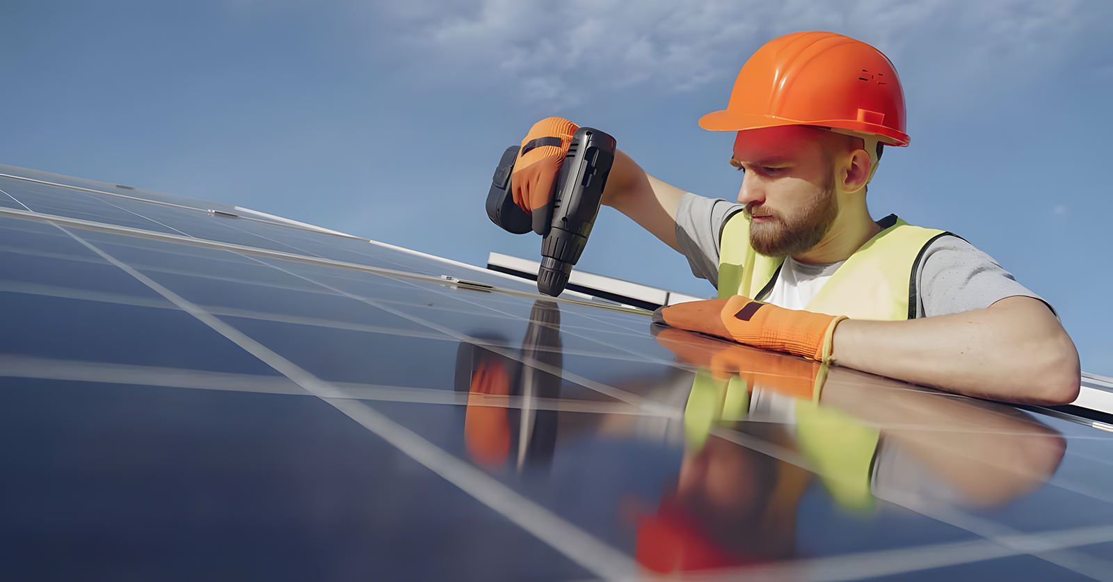 Electrician lucrând cu bormașina la panouri fotovoltaice